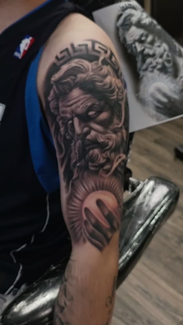 Black-and-grey bearded classical god portrait tattoo