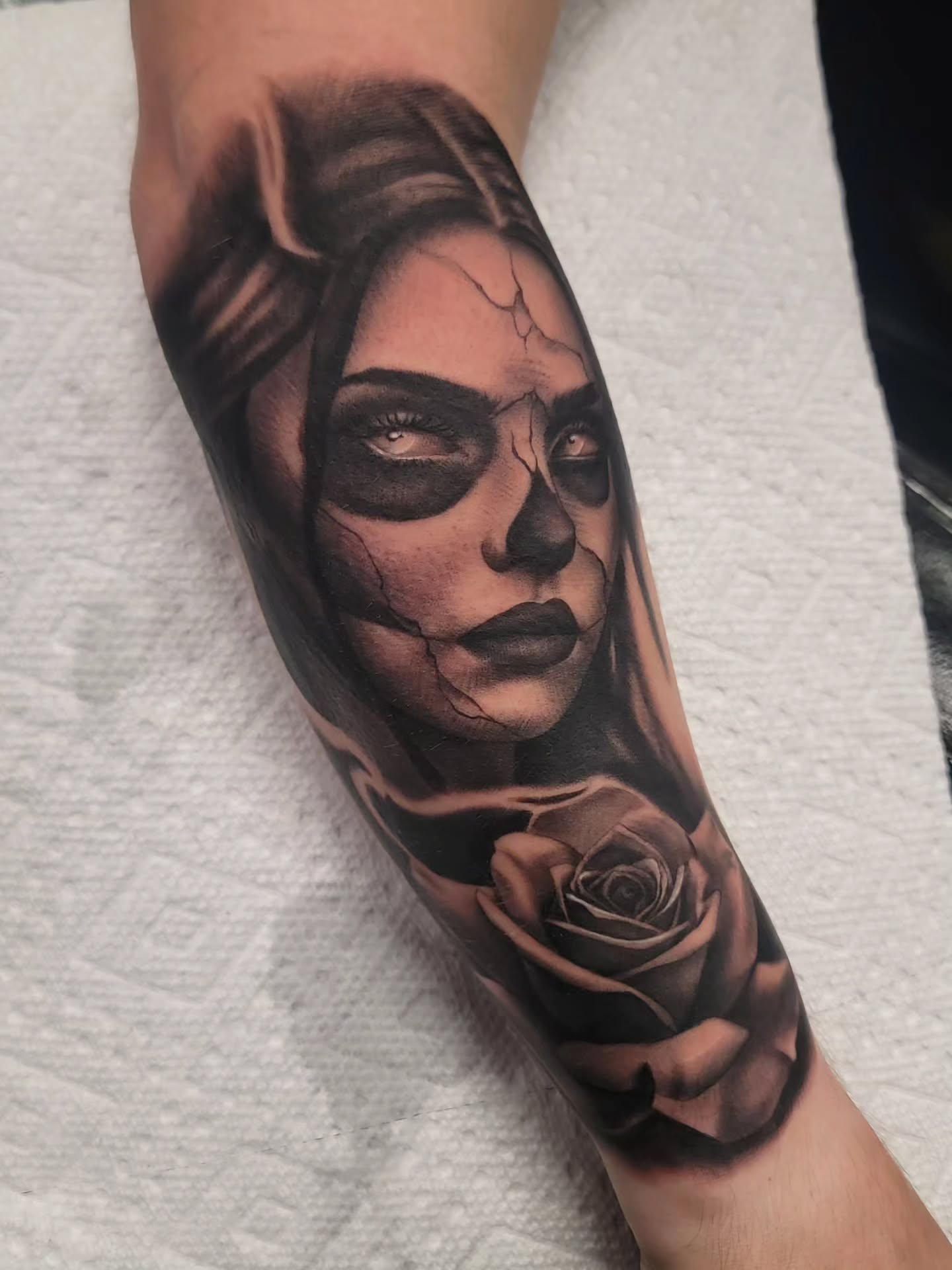 Black-and-grey cracked woman portrait tattoo with a rose