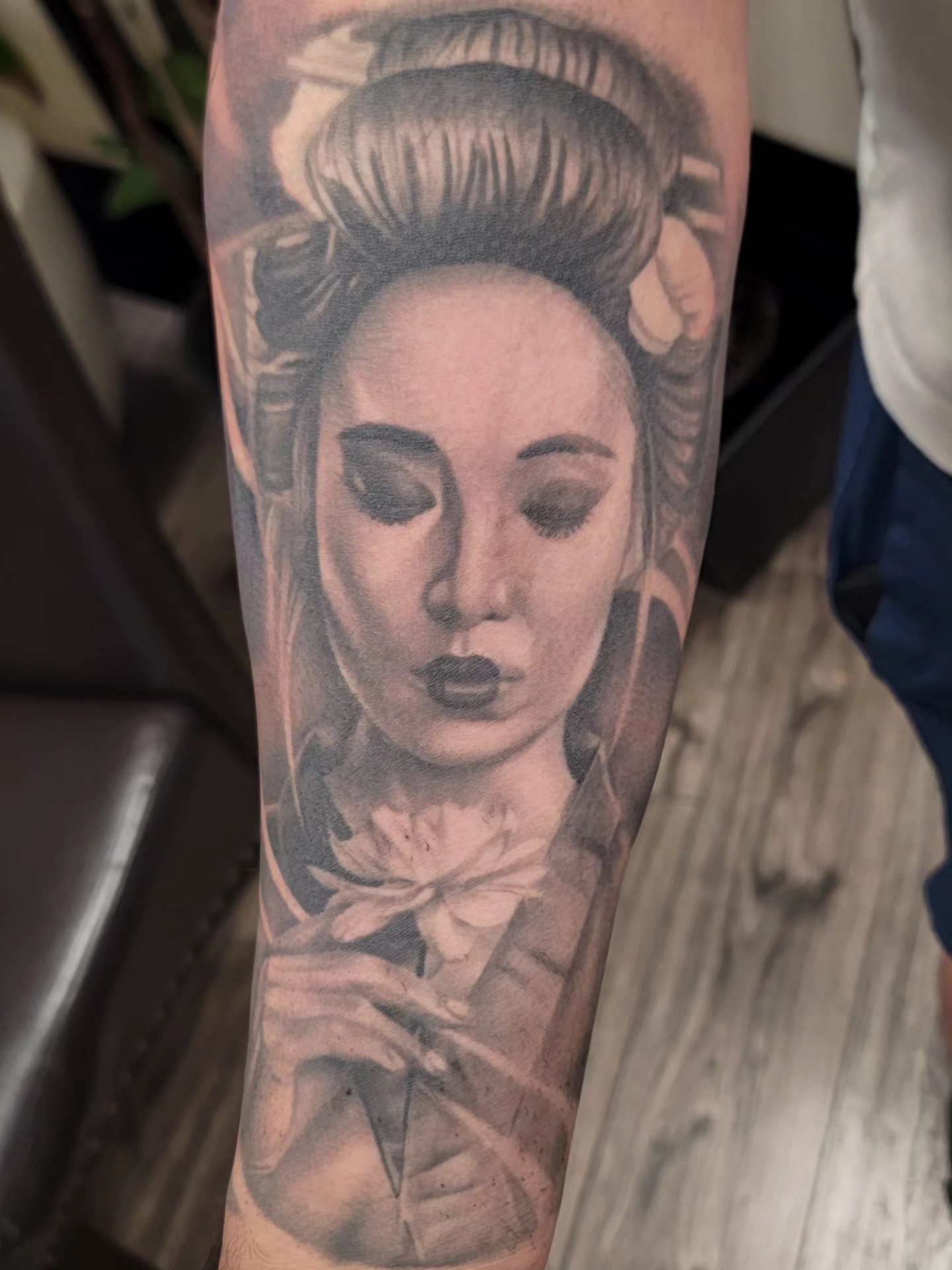 Black-and-grey geisha portrait tattoo with a flower