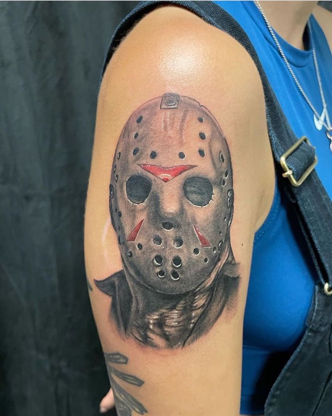 Jason Voorhees hockey-mask upper-arm tattoo with red accents