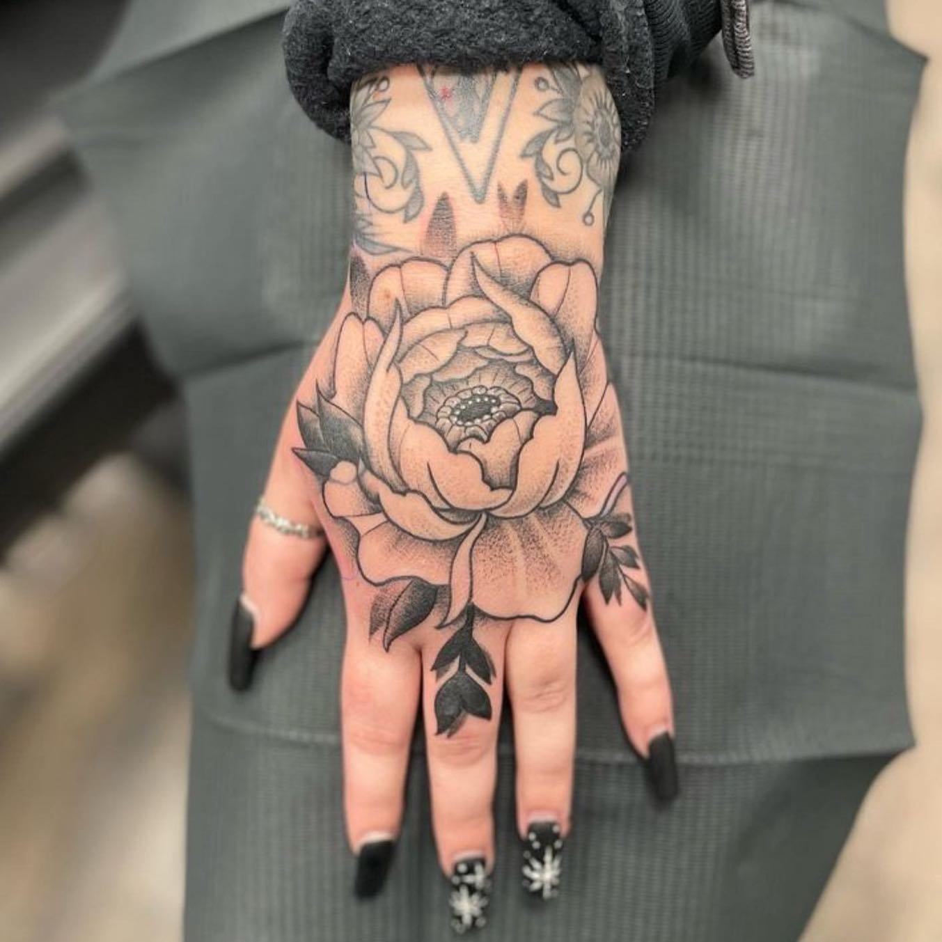 Black-and-grey peony hand tattoo